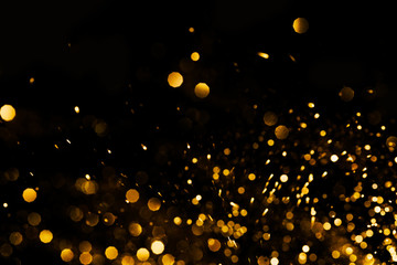 Splash of golden sparkles on black background. - 345977433