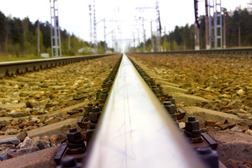 The railway rail with electric supports going into the distance