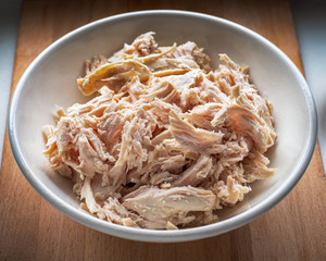 Sliced boiled chicken fillet for salads and pie toppings in a deep light plate