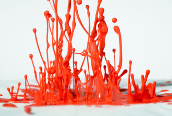 Fun shiny swirly orange red and pink paint splashes on a white background