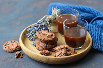 Homemade chocolate chip cookies with cacao on wooden cutting board.