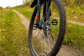 Fototapeta na wymiar Wheel of a bicycle with disc brakes on a dirt road