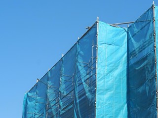 青いシートで覆われた建設中の建物