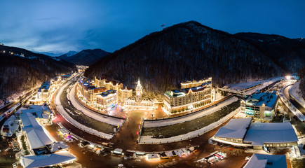 Aerial view of Rosa Khutor Ski Resort in the evening, mountains covered by snow in Krasnaya...