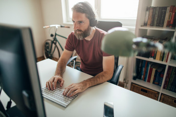 Businessman working on computer from his home office desk