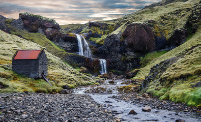 Wonderful nature of Iceland. fresh green grass and icelandic moss near river with waterfall....