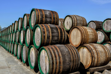 Old weathered wooden wine barrels stacked outdoors