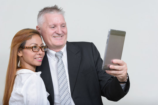 Happy mature multi ethnic business couple working together