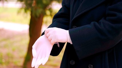 A focus on a person who is puting white latex gloves