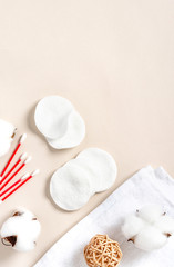 Cotton pads, towel and cotton buds on a light background, top view, free space for text. Cotton products for makeup removal and skin cleansing, flat lay, copy space.