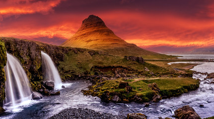 Scenic image of Iceland. Great view on famouse Mount Kirkjufell with Kirkjufell waterfall with colorful sky during sunset. Wonderful Nature landscape. Iconic location for landscape photographers