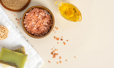 Homemade natural skin care. Pink Himalayan salt and olive oil for anti-cellulite massage. Home spa. Pink salt and oil on a light background, top view, copy space. Free space for text.