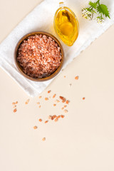 Homemade natural skin care. Pink Himalayan salt and olive oil for anti-cellulite massage. Home spa. Pink salt and oil on a light background, top view, copy space. Free space for text.