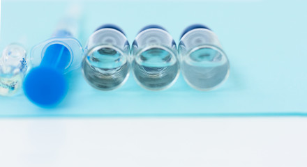injection ampoules, syringe for vaccination on a blue background, healthcare coronavirus, cancer, painand treatment, pharmaceutical medicine concept .
