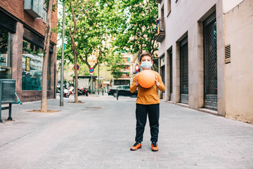 Little boy with a ball and protective mask.