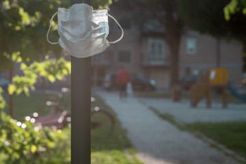 surgical mask hanged on an electricity pylon close to a playing ground