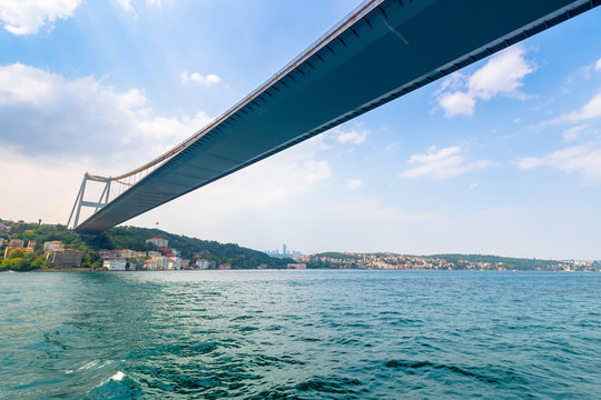 istanbul, turkey - AUG 18, 2015: fatih sultan mehmet bridge above the bosphorus. beautiful cityscape of historical area observed from the water on a sunny summer day. calm weather with fluffy clouds