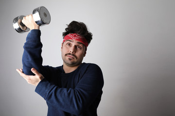 Bearded hipster man doing fitness exercises with dumbbell on grey background in retro look comic style. 
