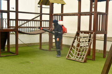 man disinfecting a playground place  against the coronavirus in Peru