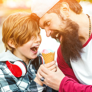 Cute kid boy eating an ice cream in a cone. Father and son having fun together. Summer vacation.