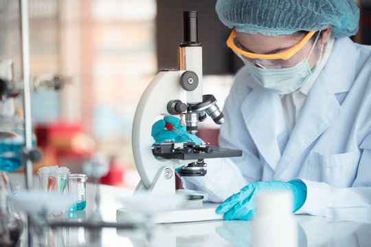 Scientist looking through microscope in laboratory with copy space using as background science, medical , education, biology, chemistry concept.