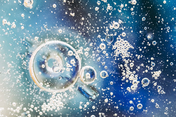 Fond de bulles abstraites - huile dans l'eau sur un arrière-plan flou dans des tons bleu blanc