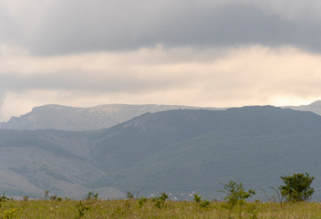 The top of the mountain valley. Mountains before the rain, gray sky covered with clouds. Mountain...