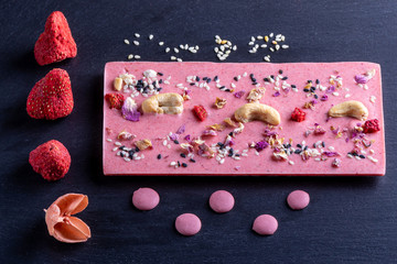 pink chocolate in assortment with hazelnuts rose petals cashew nuts