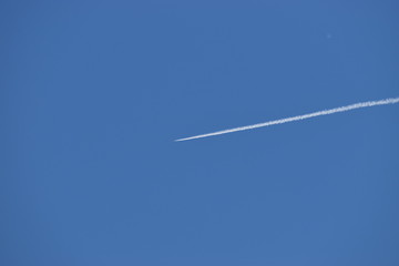 Kondensstreifen eines Flugzeugs am blauen Himmel