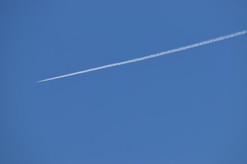 Kondensstreifen eines Flugzeugs am blauen Himmel