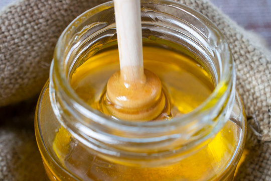 Honey stick dipped in a jar of honey. healthy life concept.