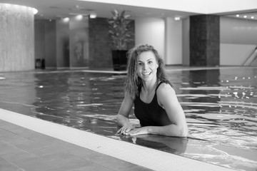 Young smiling athletic girl in a swimsuit in the pool