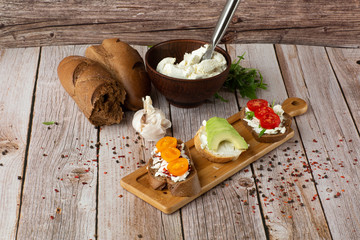 Bruschettas with vegetables. Start dishes with cherry tomatoes, avocado, cream cheese. Delicious snacks with chorizo and baked tomatoes. Food composition, tasty italian meal.