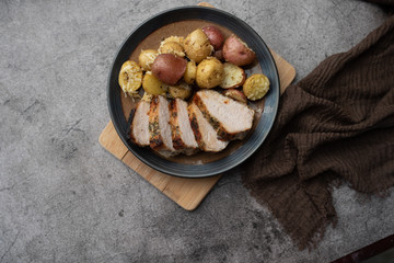 Roasted pork with spices and Parmesan roasted baby potatoes. Close up on a plate. 