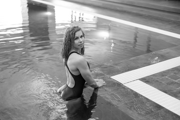 Young smiling athletic girl in a swimsuit in the pool
