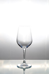 Empty wine glass on glass table with copy space for text or design.