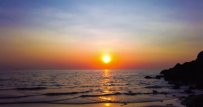 Timelapse of beautiful dramatic sunset over sea or ocean with dramatic sky and colorful fluffy clouds. 4K time lapse clip
