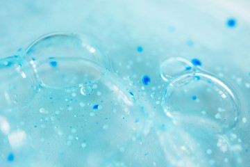 Close-up bubble blue shower gel with scrub grain texture with selective focus. Concept laboratory tests and research, making cosmetic close-up
