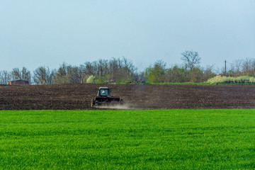 Tractor cultivates the land for spring sowing of agricultural crops