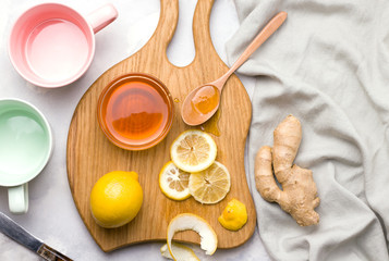 Making tea with lemon and ginger on a wooden board. virus products concept