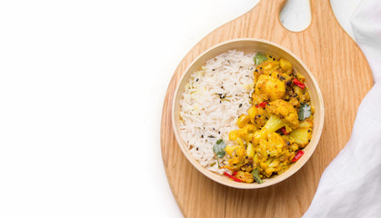 Indian traditional cuisine. Gobi aloo cauliflower dish with rice on a white background. Copy space