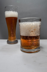 Closeup of pouring gold beer two on grey background for concept design. Summer concept.