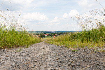Schotterweg von Feldern umgeben f&uuml;ht den Berg herunter