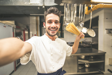 Italian chef of a restaurant taking a selfie cooking spaghetti food. 