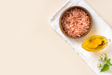 Homemade natural skin care. Pink Himalayan salt and olive oil for anti-cellulite massage. Home spa. Pink salt and oil on a light background, top view, copy space. Free space for text.