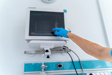 Intensive Care Unit. Very sick man lying on the bed. Doctor checks his vital signs