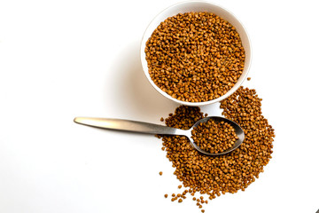 buckwheat in a white cup with a metal spoon