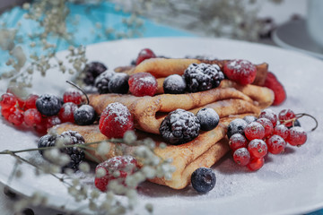 .Breakfast close up. Red currant, berry closeup. Pancakes with berries. Tasty breakfast with berries and icing sugar