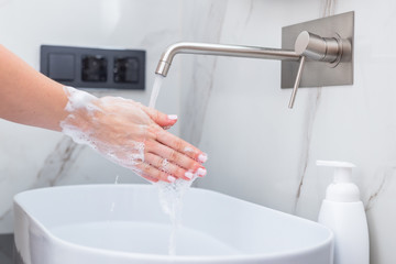 Woman washing hands with foam soap. Hygiene, preventing coronavirus