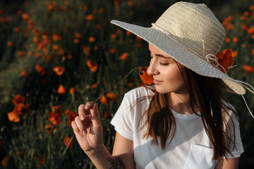 Romantic girl at sunset in poppy field - 345997094